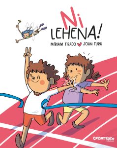 «Ni lehena!» liburuaren azala. Bi haur agertzen dira: mutilak helmuga-zinta bat zeharkatzen ari da korrika eta poz-pozik eta atzean daukan neska eskuarekin aldentzen du. Gainean maitagarri bat dago hegan.